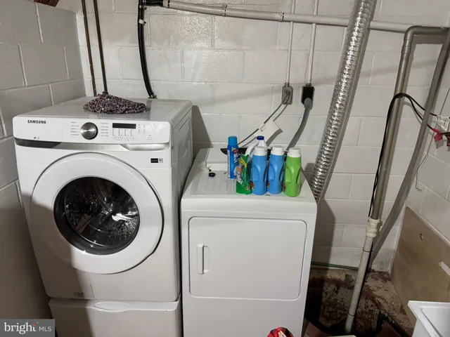 a view of a storage & utility room with sink dryer and washer