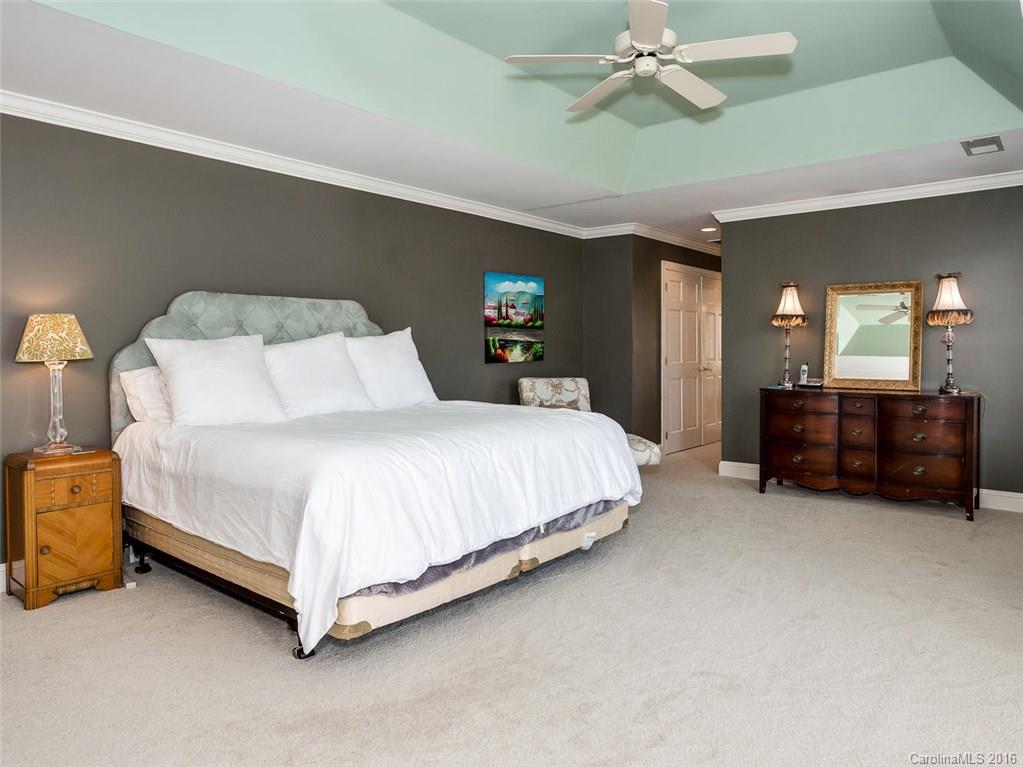 4822 Nora's Path Road Charlotte, NC 28226 - Photo 16 of 24 a spacious bedroom with a bed and a chandelier