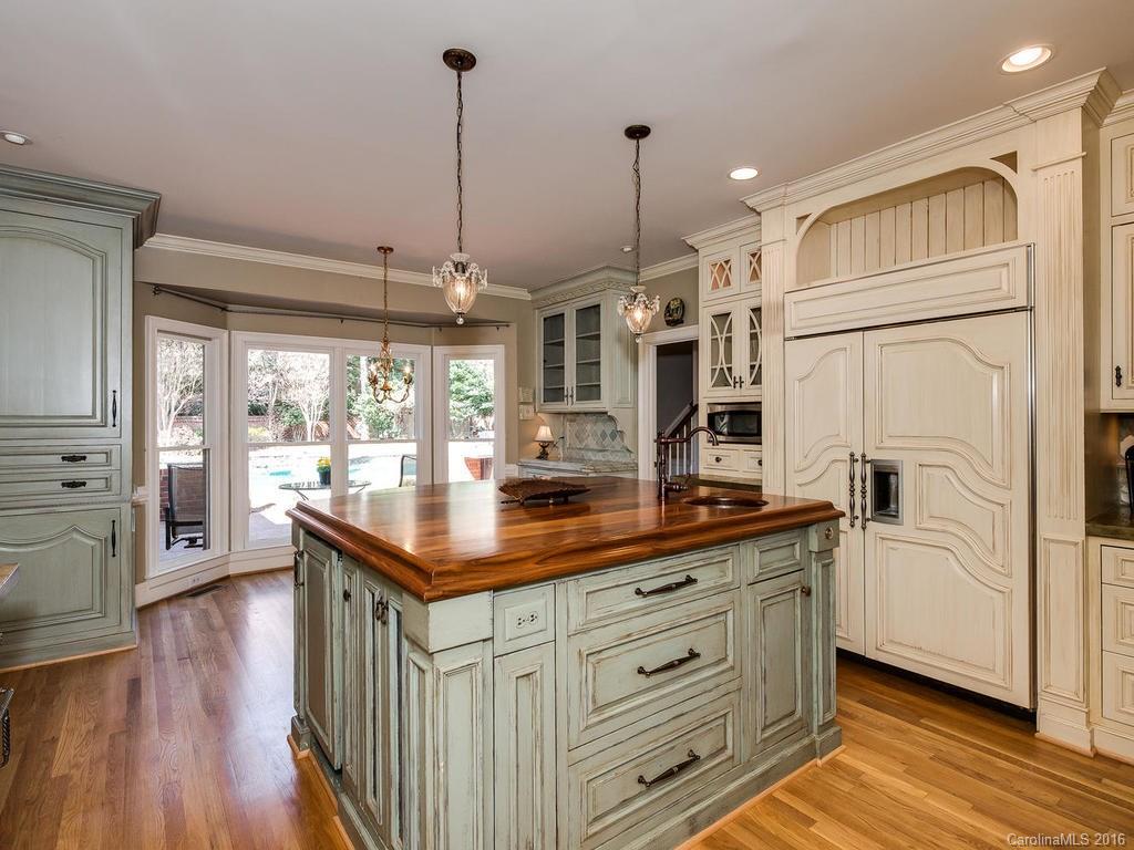 4822 Nora's Path Road Charlotte, NC 28226 - Photo 10 of 24 a kitchen with stainless steel appliances granite countertop a refrigerator a sink dishwasher a oven and a dining table with wooden floor