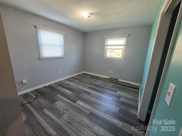 a view of a room with wooden floor and window