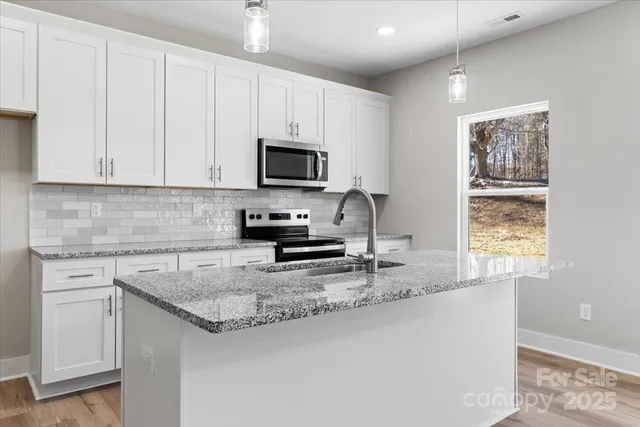 an empty room with closet and a chandelier fan