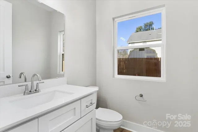 a kitchen with granite countertop white cabinets stainless steel appliances and a window