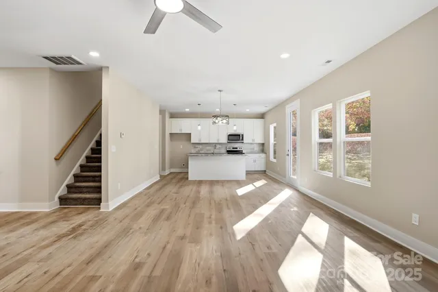 an empty room with a window and a fan