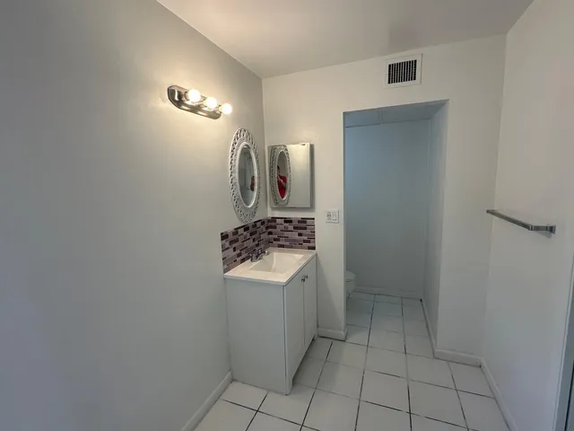 a kitchen with a sink a refrigerator and cabinets