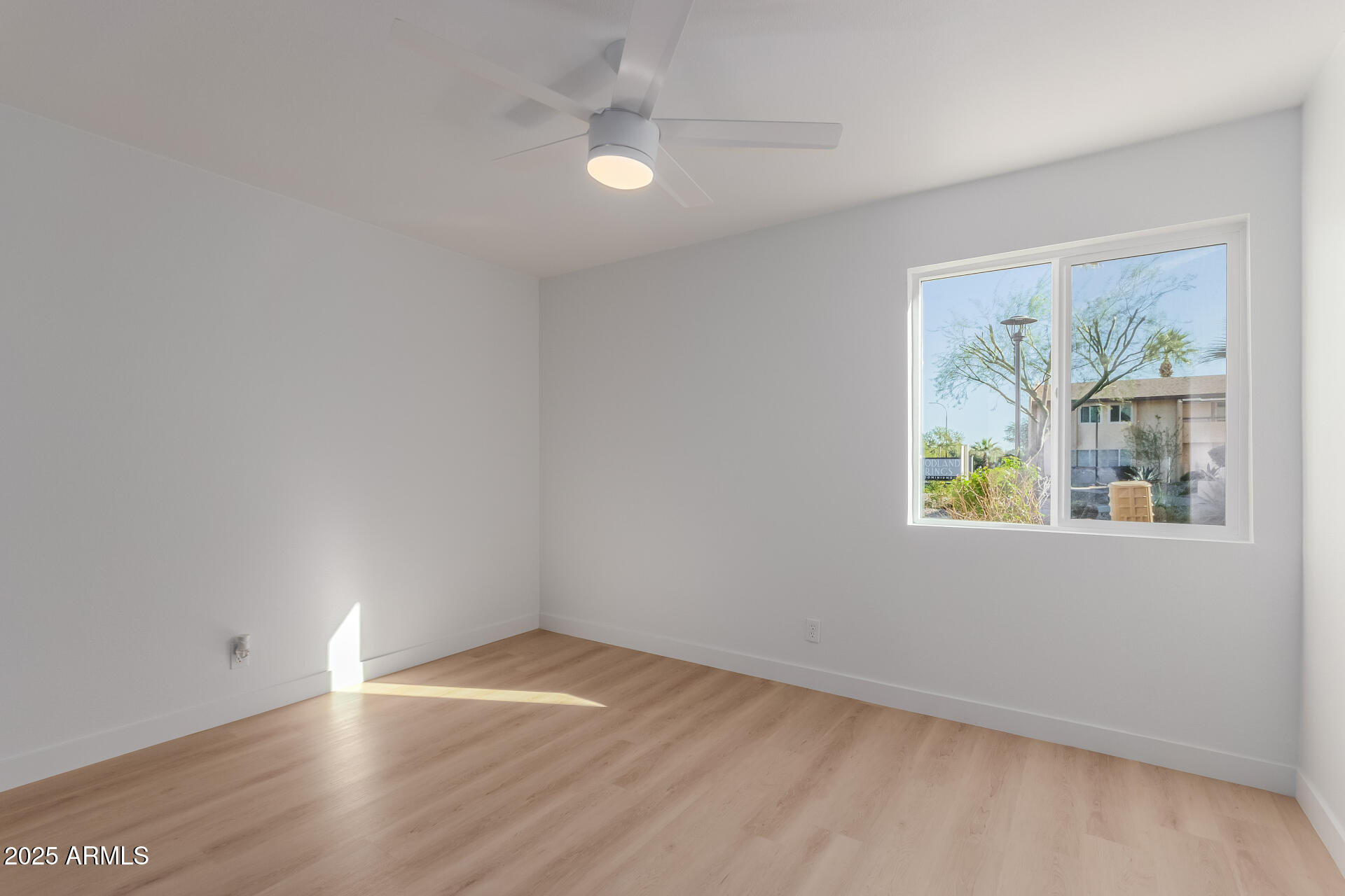 8055 East Thomas Road, Unit M101 Scottsdale, AZ 85251 - Photo 13 of 33 an empty room with wooden floor and window