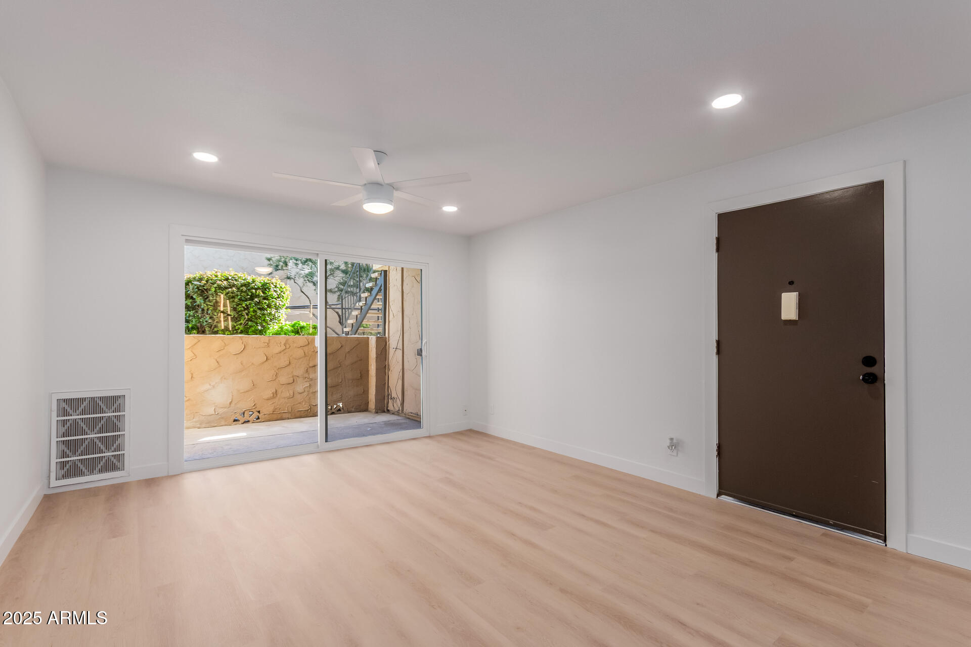 8055 East Thomas Road, Unit M101 Scottsdale, AZ 85251 - Photo 6 of 33 an empty room with wooden floor and windows