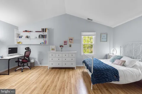 a room with gym equipment and wooden floor