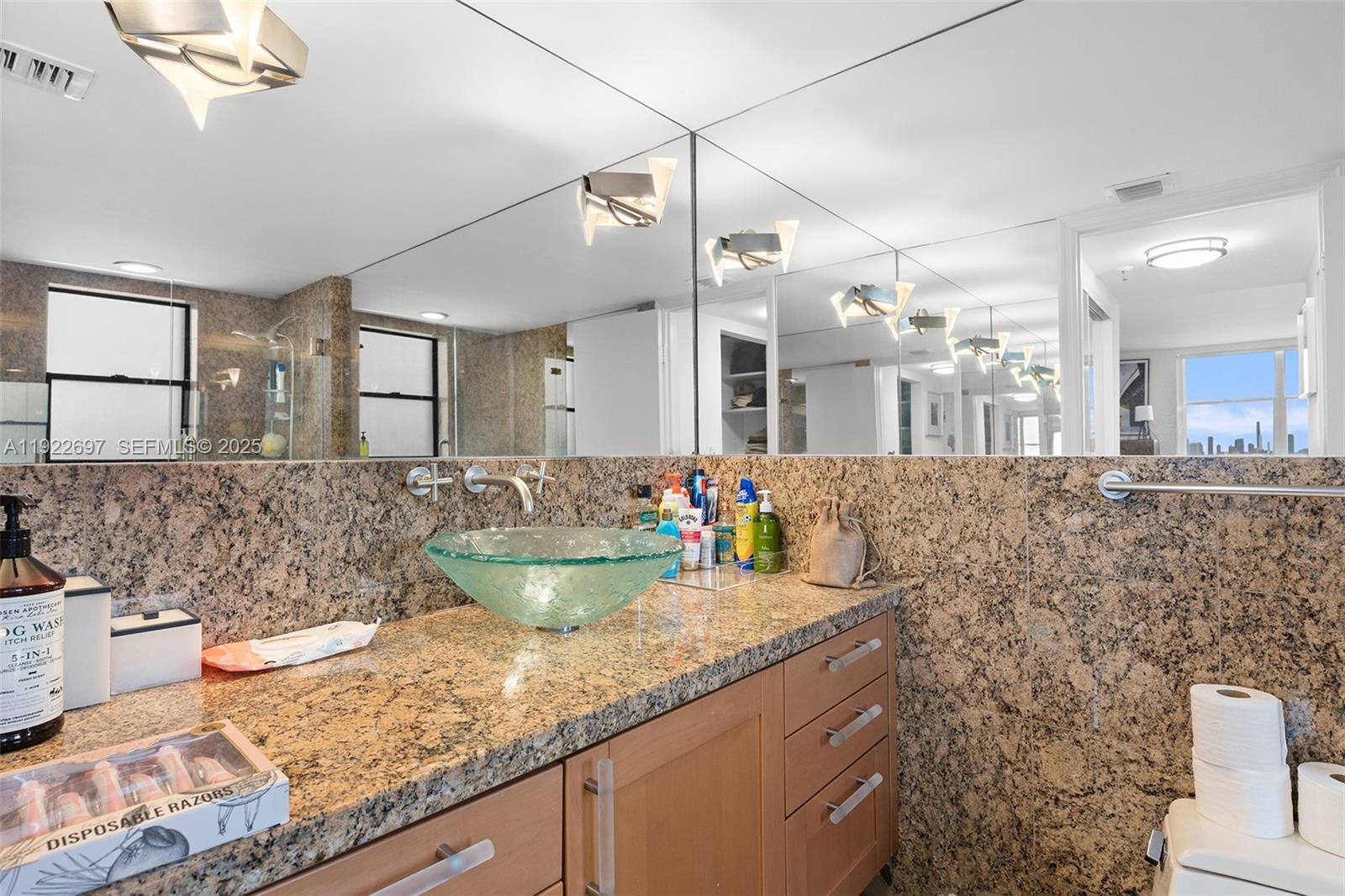 1775 Washington Avenue, Unit 14F Miami Beach, FL 33139 - Photo 17 of 25 a kitchen with sink and a large mirror