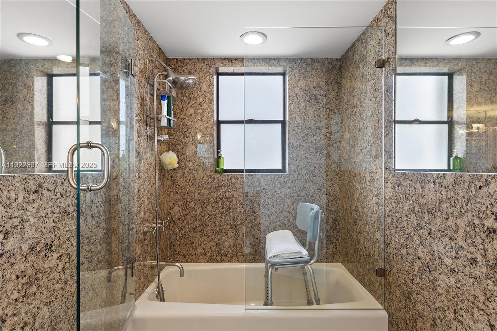 1775 Washington Avenue, Unit 14F Miami Beach, FL 33139 - Photo 18 of 25 a bathroom with a bathtub a shower a sink and a window