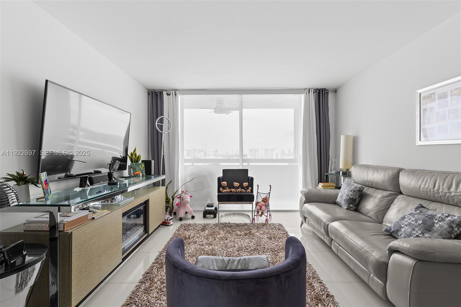 1775 Washington Avenue, Unit 14F Miami Beach, FL 33139 - Photo 3 of 25 a living room with furniture and a flat screen tv