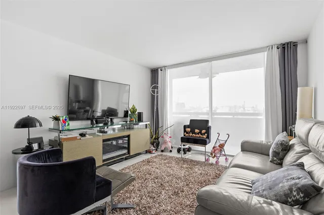 a living room with furniture a large window and a flat screen tv