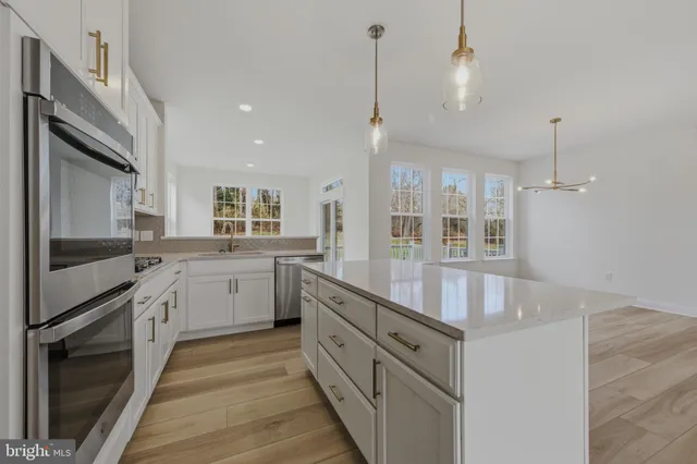 a kitchen with counter top space a sink stainless steel appliances and cabinets