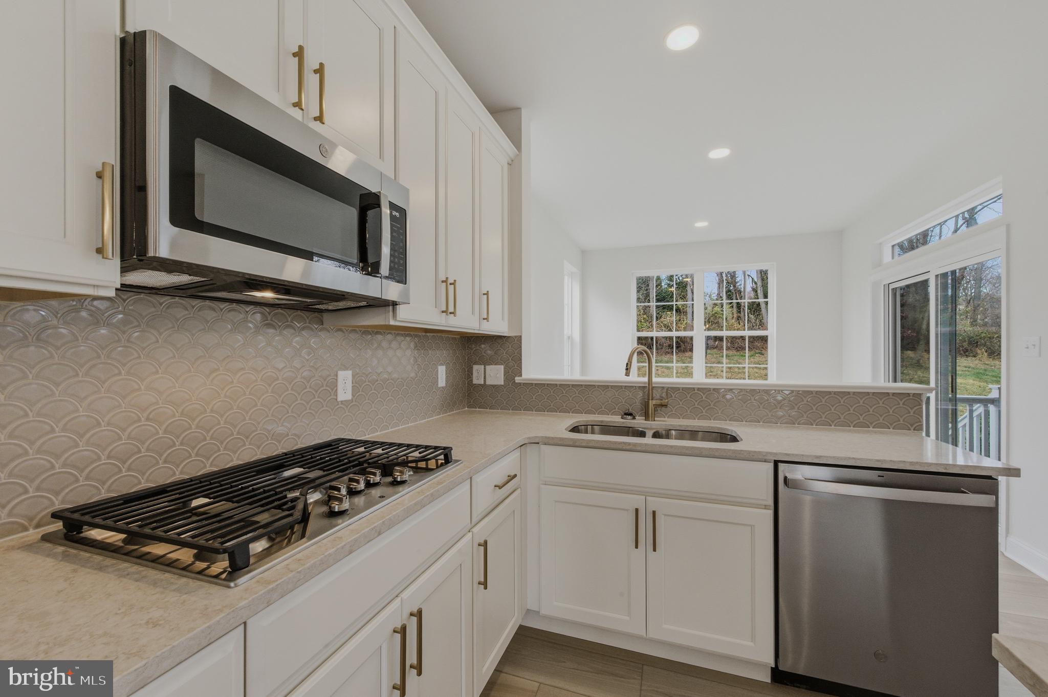 253 Grove View Drive Hockessin, DE 19707 - Photo 8 of 25 a kitchen with stainless steel appliances a sink stove and microwave