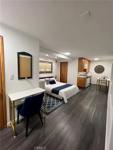 a bedroom with furniture wooden floor and window