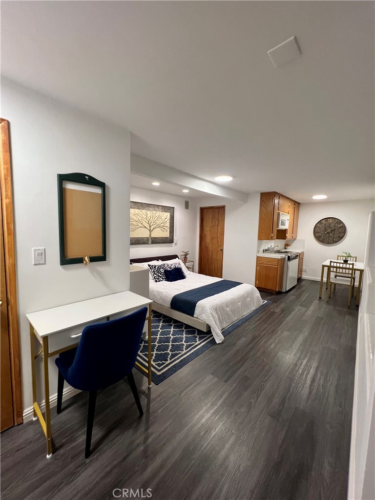 a bedroom with furniture wooden floor and window