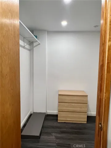 a view of space wooden floor and windows