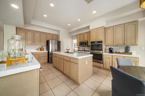 a kitchen with a sink a counter top space stainless steel appliances and cabinets