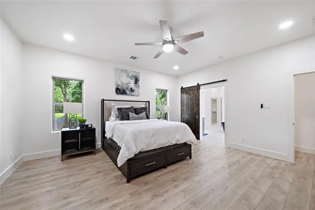 a spacious bedroom with a large bed and a chandelier