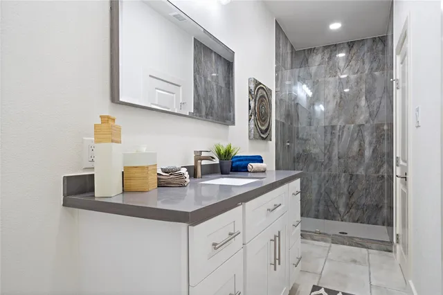 a bathroom with a shower sink and mirror