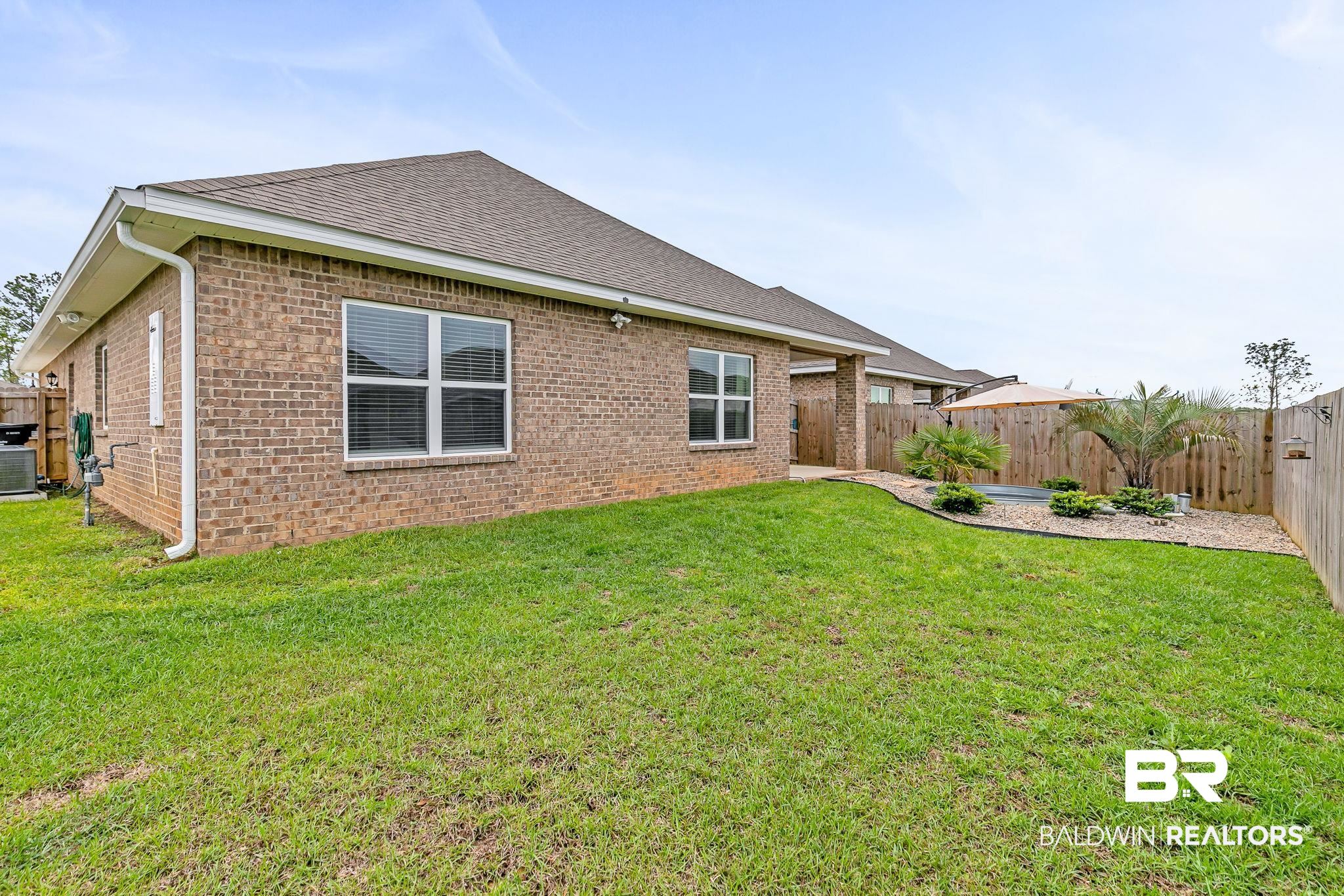 31650 Memphis Loop Daphne, AL 36527 - Photo 43 of 68 Rear view of property with a fenced backyard, brick siding, a patio, and roof with shingles