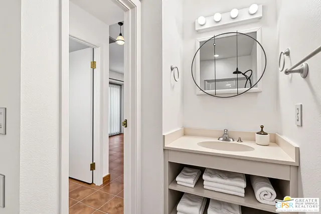 a bathroom with a granite countertop sink a mirror and a shower