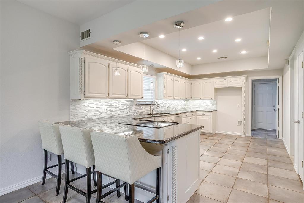 11972 Younger Court Azle, TX 76020 - Photo 11 of 40 a kitchen with kitchen island granite countertop a sink and white cabinets