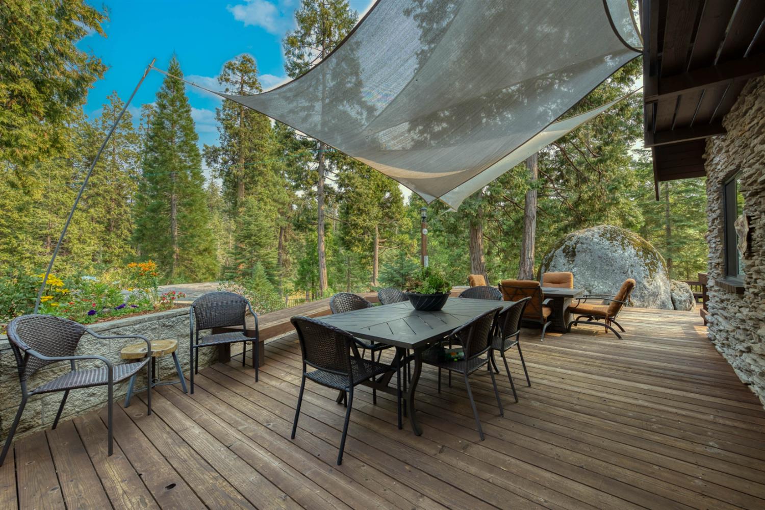 38848 Ridge Road Shaver Lake, CA 93664 - Photo 15 of 81 a view of a patio with table and chairs and potted plants with wooden floor and fence