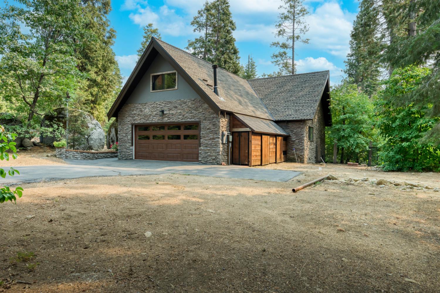 38848 Ridge Road Shaver Lake, CA 93664 - Photo 5 of 81 a front view of a house with a yard and garage