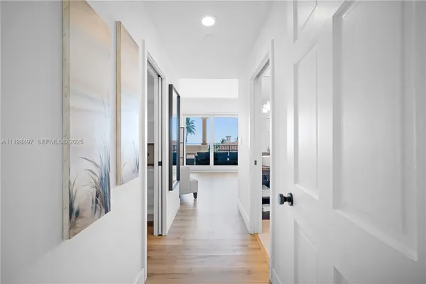 a view of a hallway with wooden floor and staircase