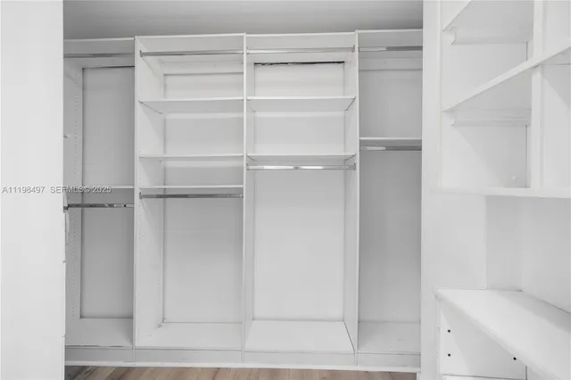 a view of walk in closet with empty racks