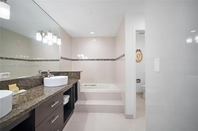 a bathroom with a granite countertop sink a large mirror and a shower