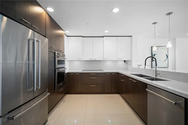 a kitchen with stainless steel appliances granite countertop a refrigerator a sink and wooden cabinets