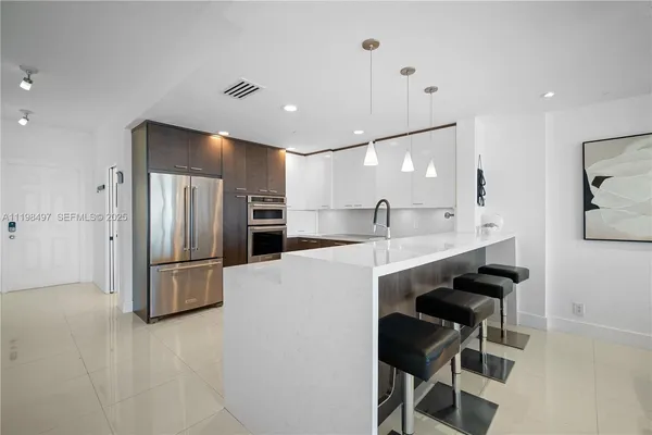 a large kitchen with a refrigerator a sink and a stove
