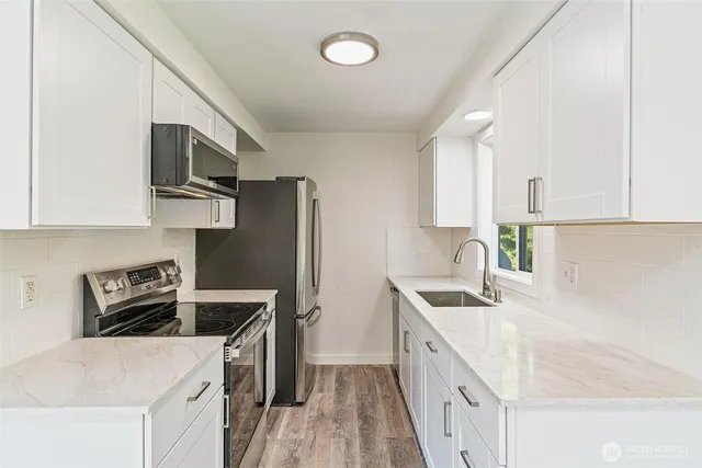 a kitchen with stainless steel appliances granite countertop a sink stove and refrigerator
