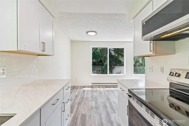 a kitchen with a wooden floor and a large window