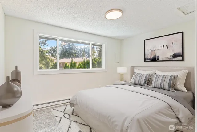 a bedroom with a bed and a painting on the wall