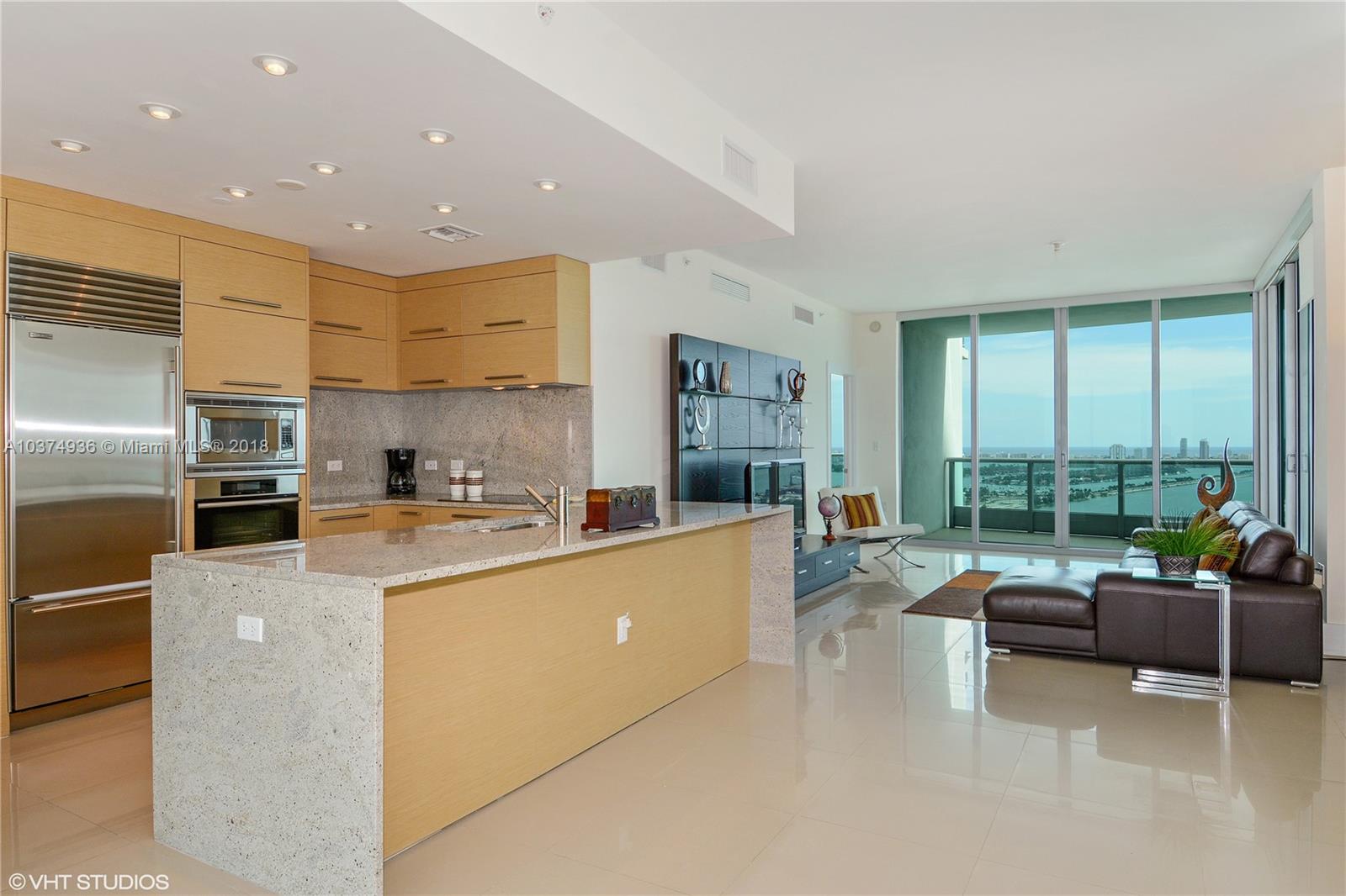 a large kitchen with a large window and stainless steel appliances