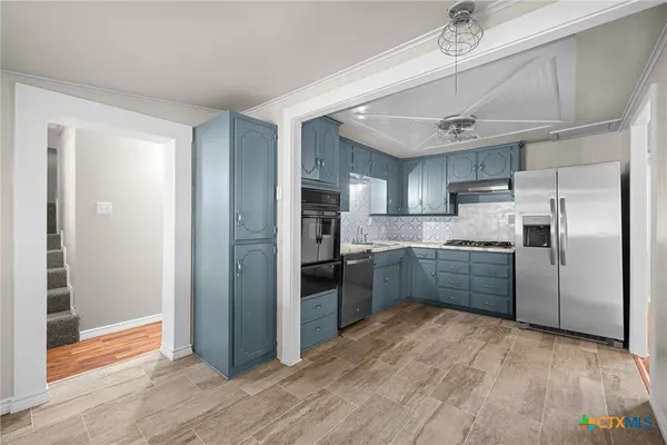 a kitchen with stainless steel appliances granite countertop a refrigerator and a sink