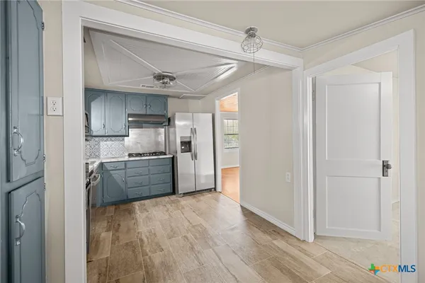 a kitchen with stainless steel appliances a refrigerator and a stove top oven