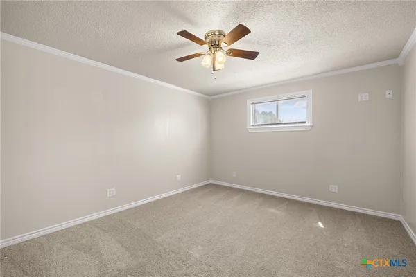 an empty room with a ceiling fan and a window