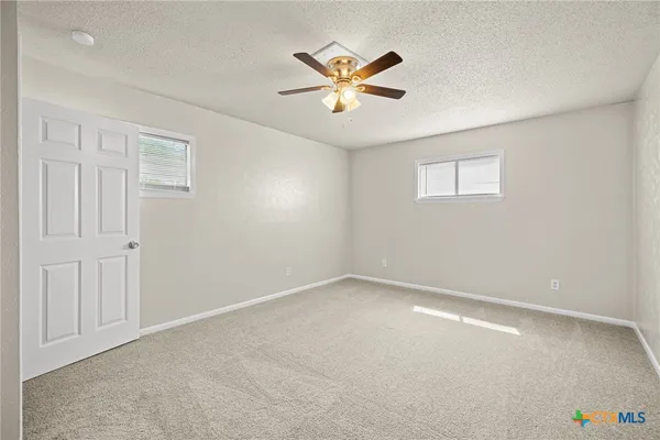a view of an empty room with a ceiling fan
