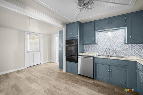 a kitchen with a sink cabinets and stainless steel appliances