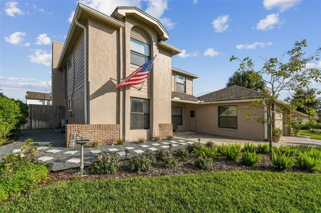 an aerial view of a house with a garden and lake view