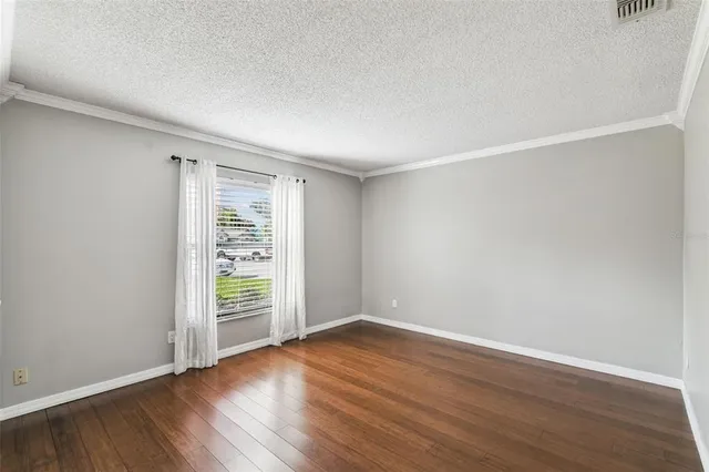 a open kitchen with a refrigerator a oven a stove a sink and a dining table with wooden floor