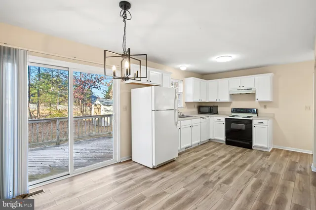 a kitchen with white cabinets and white appliances