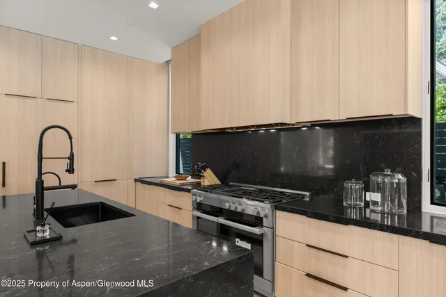 a kitchen with granite countertop a stove and a sink