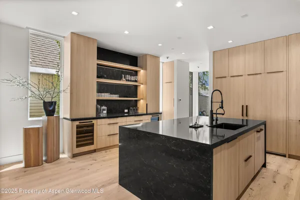 a kitchen with stainless steel appliances granite countertop a sink and a refrigerator