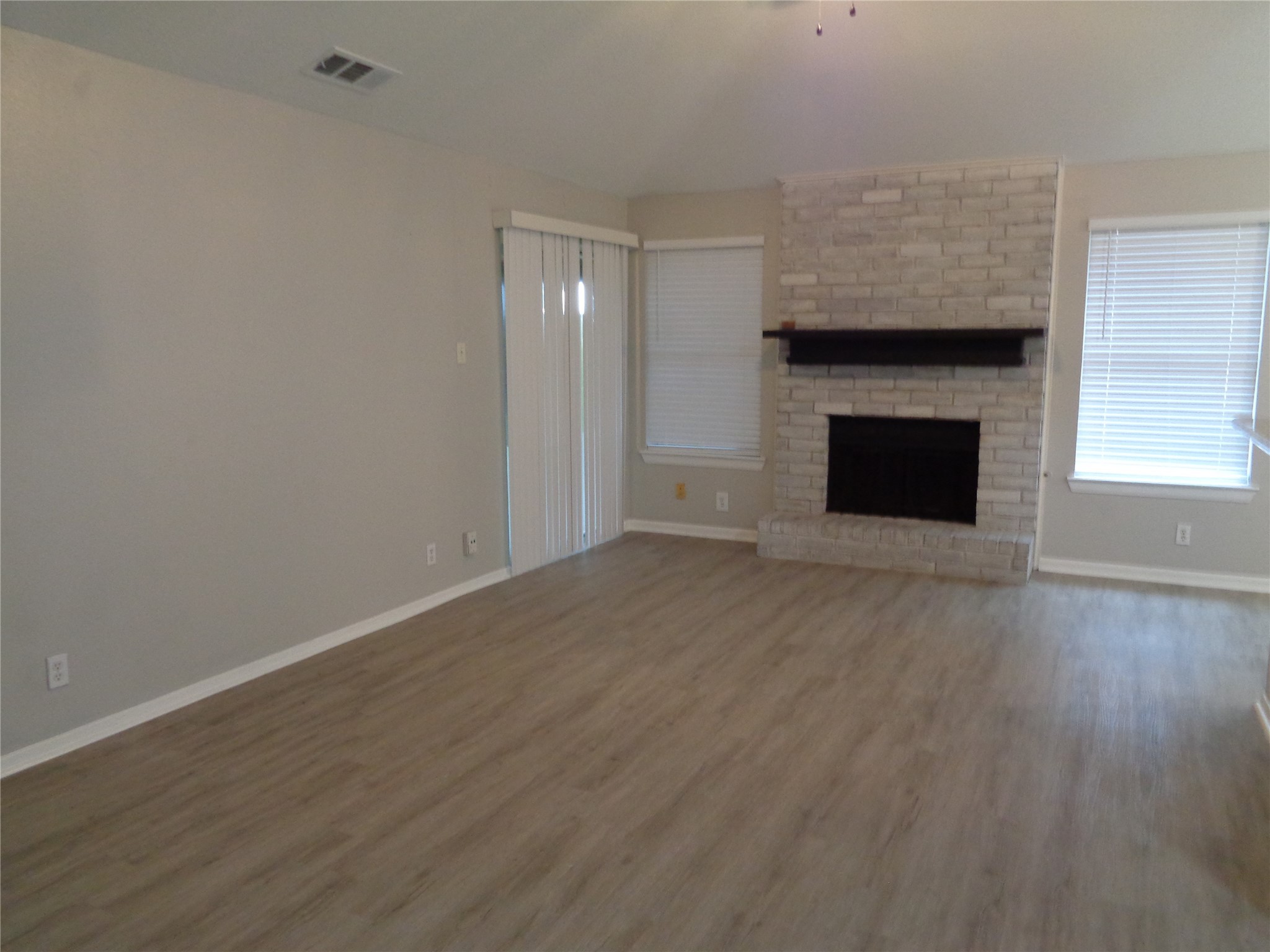 1229 Clover Drive Angleton, TX 77515 - Photo 2 of 7 a view of empty room with wooden floor and fireplace