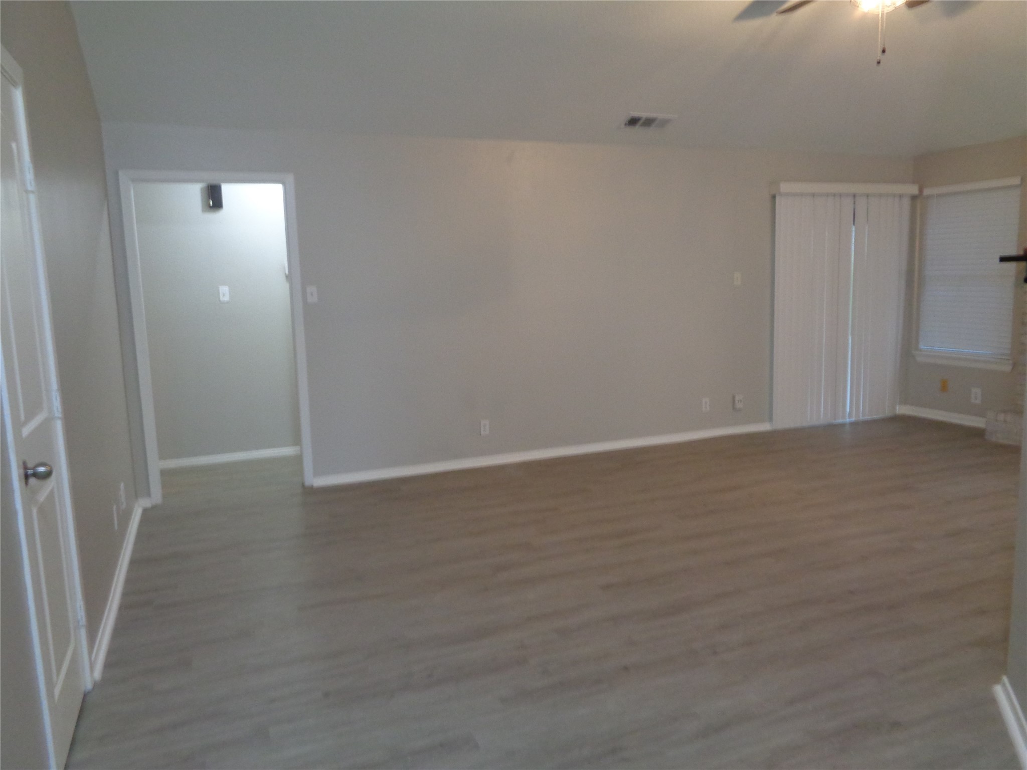 1229 Clover Drive Angleton, TX 77515 - Photo 4 of 7 a view of an empty room with wooden floor and a window