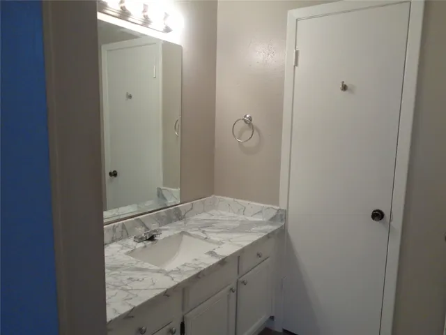 a bathroom with a granite countertop sink and mirror